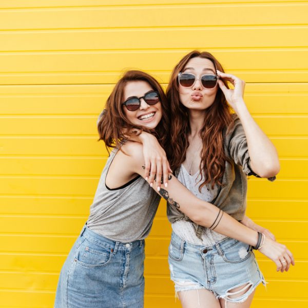 Image,Of,Two,Young,Happy,Women,Friends,Standing,Over,Yellow