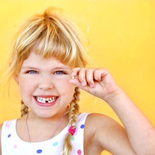 Smiling,Girl,Holding,Missing,Tooth